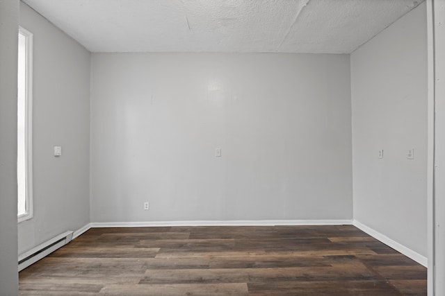 unfurnished room featuring a baseboard heating unit, dark wood-type flooring, and a textured ceiling