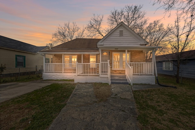 view of front of house with a lawn and a porch