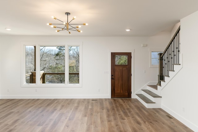 foyer entrance with hardwood / wood-style flooring and a notable chandelier