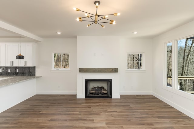 unfurnished living room with dark hardwood / wood-style flooring and a notable chandelier