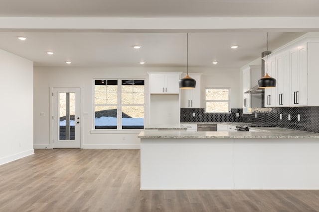 kitchen with kitchen peninsula, light stone countertops, pendant lighting, stainless steel dishwasher, and white cabinets