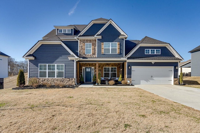 craftsman inspired home with a garage, a front yard, and covered porch