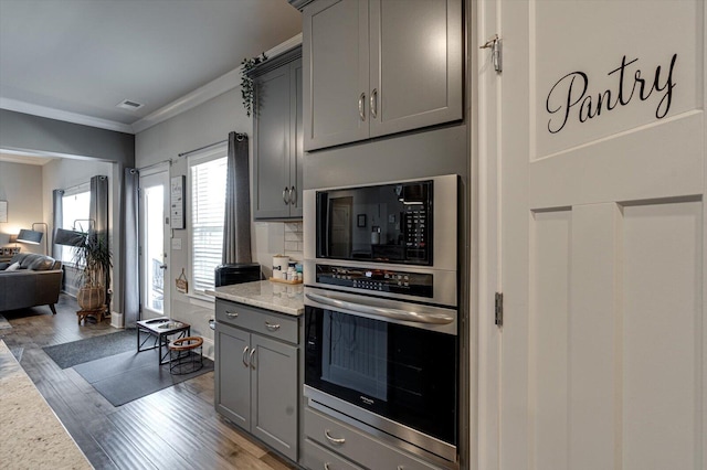 kitchen featuring hardwood / wood-style flooring, gray cabinets, and ornamental molding