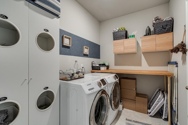 laundry area featuring cabinets, washing machine and clothes dryer, and light tile patterned flooring