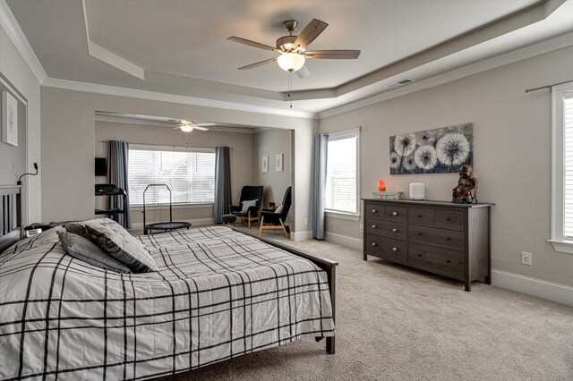 carpeted bedroom featuring a raised ceiling, crown molding, and ceiling fan