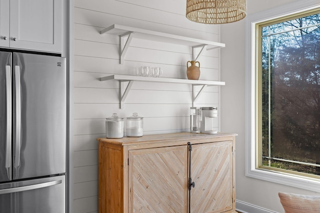 bar with wood walls, wooden counters, and stainless steel refrigerator