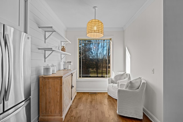 sitting room featuring crown molding and light hardwood / wood-style flooring