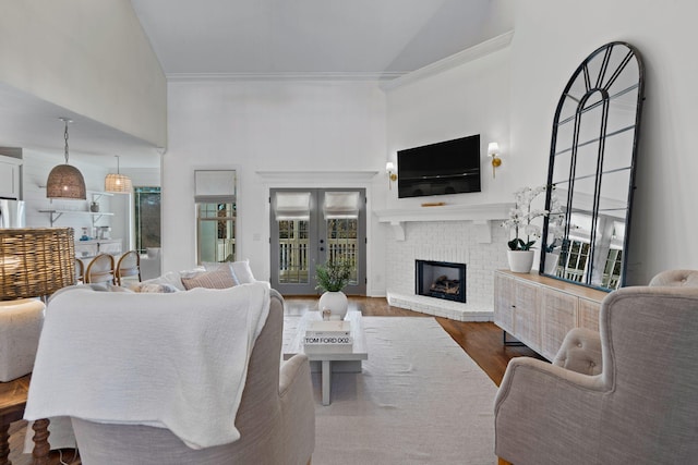 living room with high vaulted ceiling, a fireplace, and hardwood / wood-style floors