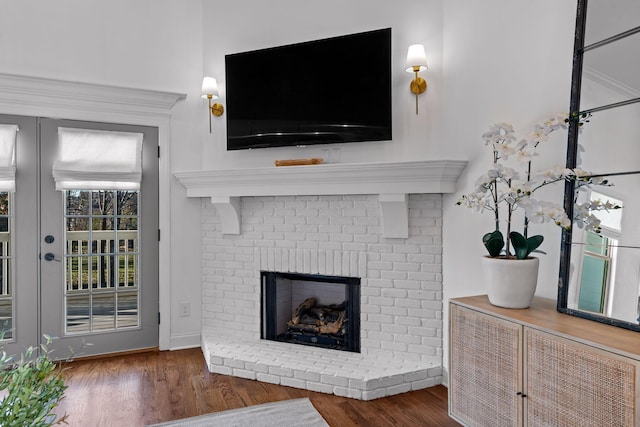 living room featuring dark wood-type flooring, french doors, and a fireplace