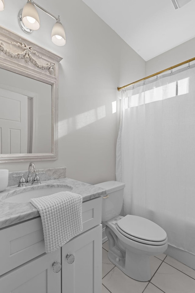 bathroom featuring toilet, vanity, and tile patterned flooring