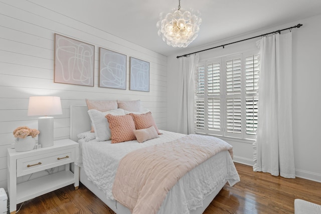 bedroom featuring dark wood-type flooring and a chandelier