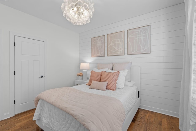 bedroom with a chandelier and dark hardwood / wood-style floors