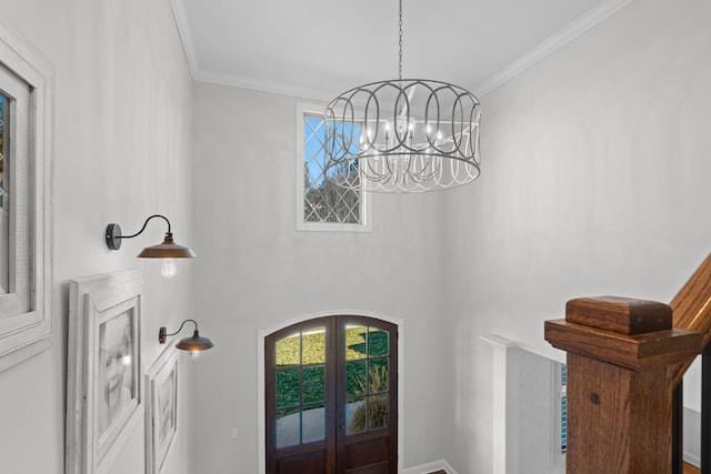 foyer with french doors, a notable chandelier, and crown molding