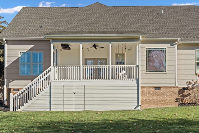 back of property with ceiling fan, a porch, and a lawn