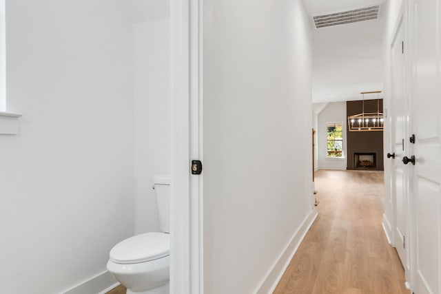 corridor featuring a chandelier and light hardwood / wood-style flooring