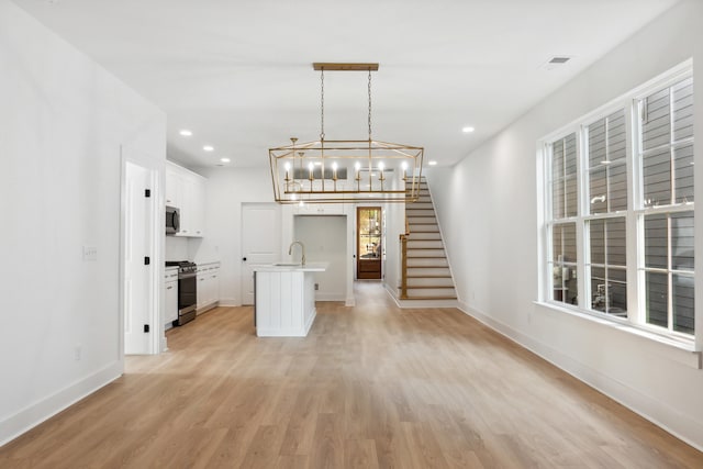 interior space featuring sink, a chandelier, and light wood-type flooring