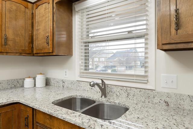 kitchen featuring sink and light stone countertops