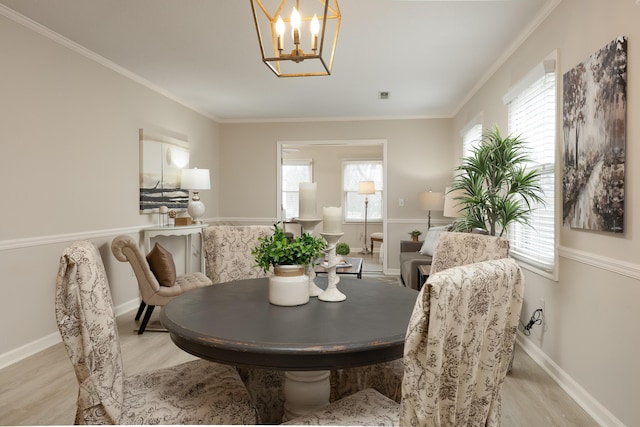 dining room with a wealth of natural light, crown molding, and light wood-type flooring