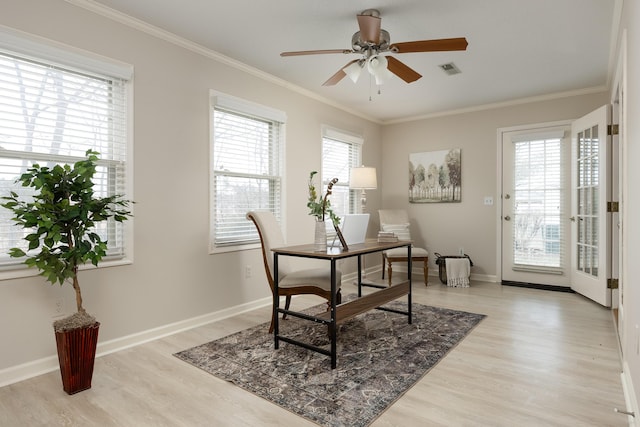 office space with plenty of natural light, light wood-type flooring, and ornamental molding