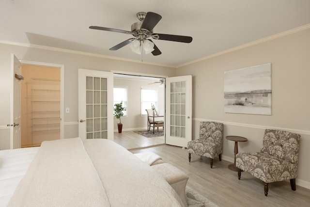 bedroom featuring light hardwood / wood-style floors, a closet, french doors, ornamental molding, and ceiling fan