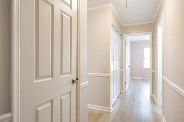 corridor featuring light wood-type flooring and ornamental molding