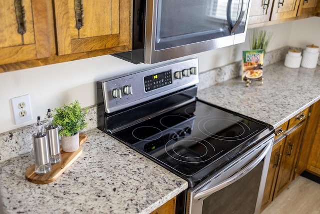 kitchen featuring light stone counters and appliances with stainless steel finishes