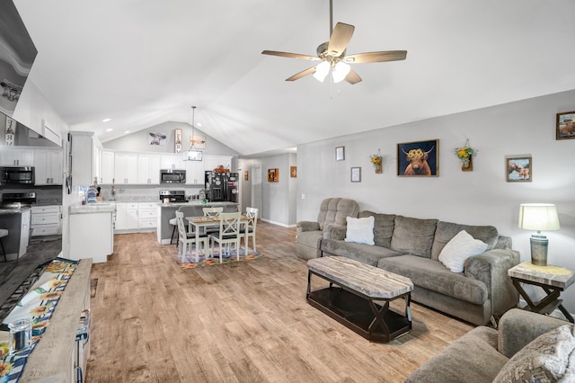 living room with light wood-type flooring, ceiling fan, and lofted ceiling