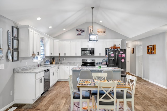 kitchen featuring white cabinetry, stainless steel appliances, decorative light fixtures, a kitchen island, and sink