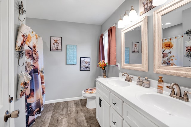 bathroom featuring wood-type flooring, toilet, and vanity