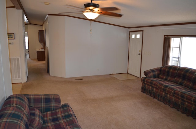 carpeted living room with ceiling fan and ornamental molding