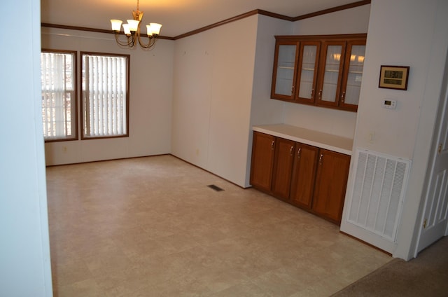 unfurnished dining area featuring a chandelier and crown molding