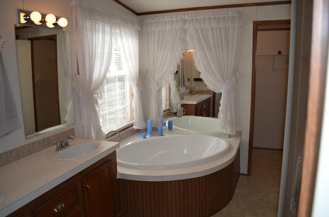 bathroom with tile patterned flooring, vanity, a tub, and ornamental molding