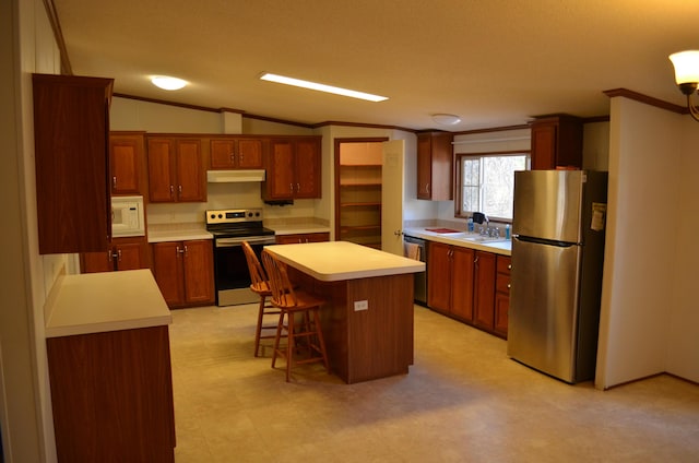 kitchen with a breakfast bar, stainless steel appliances, lofted ceiling, and a kitchen island