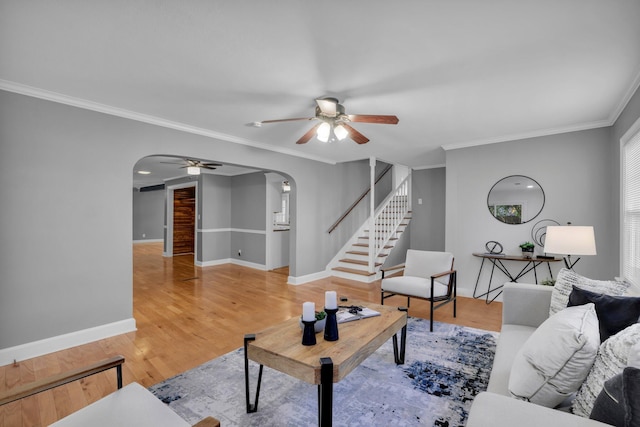 living room with wood-type flooring, ceiling fan, and ornamental molding