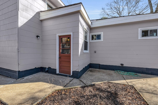 view of exterior entry with a patio