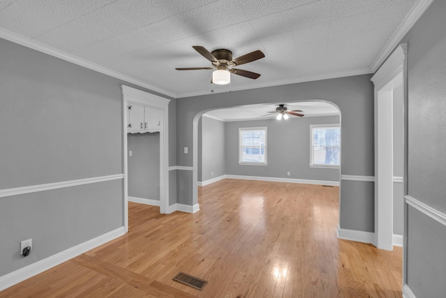 unfurnished room featuring light hardwood / wood-style floors, crown molding, and ceiling fan