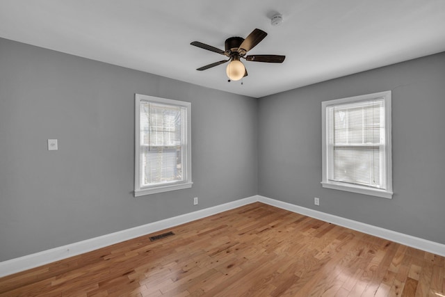 unfurnished room with light hardwood / wood-style floors, a wealth of natural light, and ceiling fan