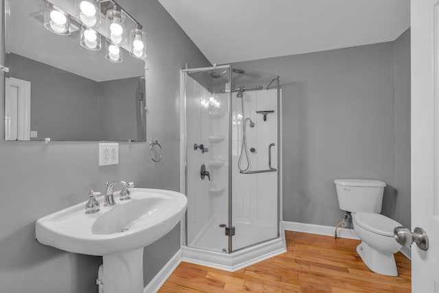 bathroom with a shower with shower door, wood-type flooring, and toilet