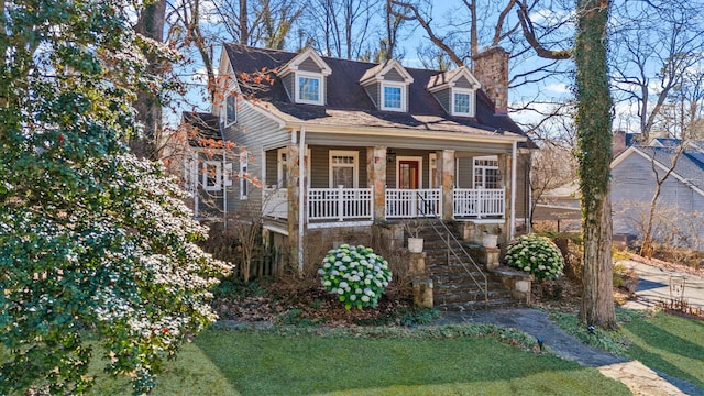 new england style home featuring a front lawn and covered porch