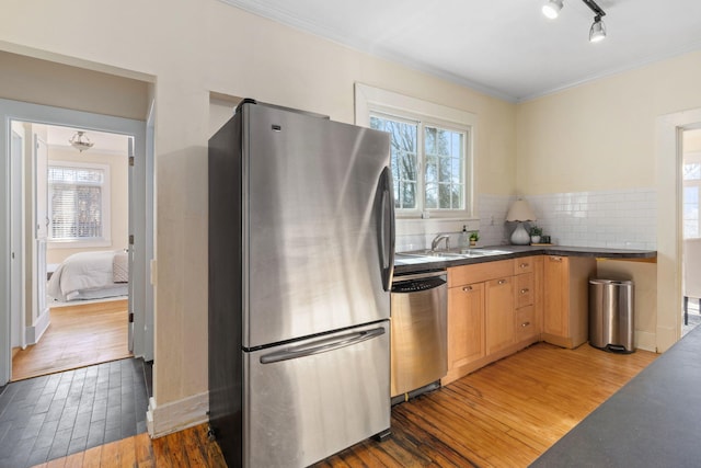 kitchen with dark wood-type flooring, light brown cabinetry, crown molding, tasteful backsplash, and stainless steel appliances