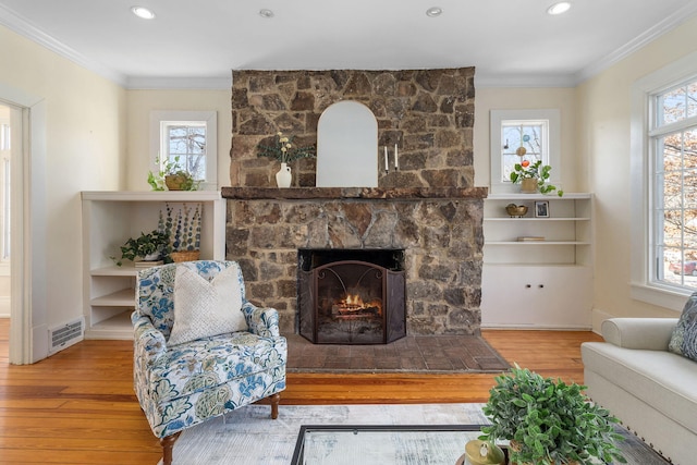 living room with hardwood / wood-style flooring, ornamental molding, and plenty of natural light