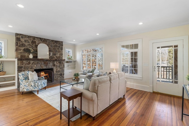 living room with crown molding, a fireplace, and hardwood / wood-style floors