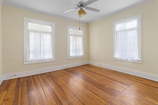 empty room featuring hardwood / wood-style flooring, ornamental molding, and ceiling fan