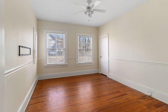 empty room featuring dark wood-type flooring and ceiling fan