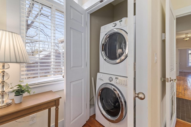 washroom featuring stacked washer / dryer and hardwood / wood-style flooring