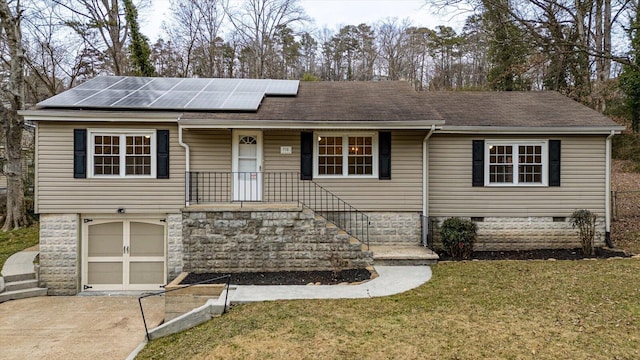 ranch-style home featuring a front yard, a garage, and solar panels