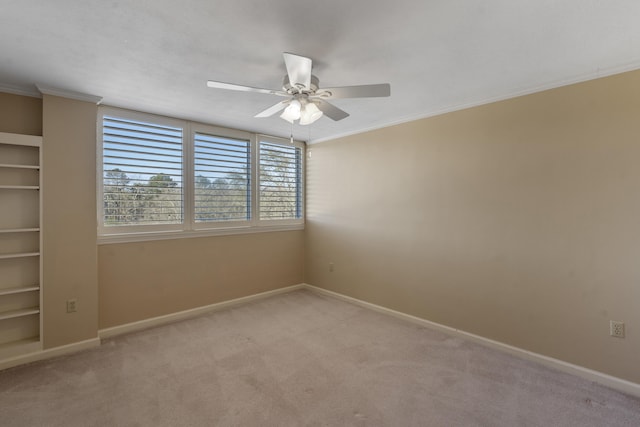 carpeted empty room featuring crown molding and ceiling fan