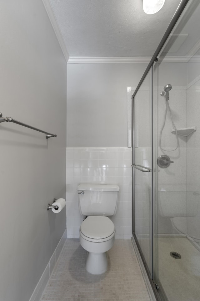 bathroom with a shower with shower door, tile walls, toilet, and tile patterned flooring