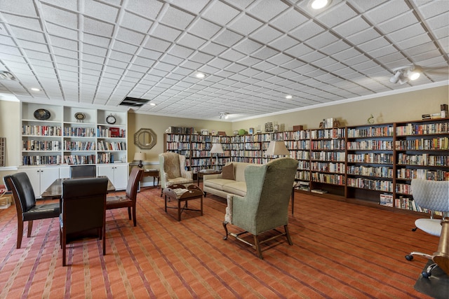 sitting room with built in features, carpet flooring, and crown molding