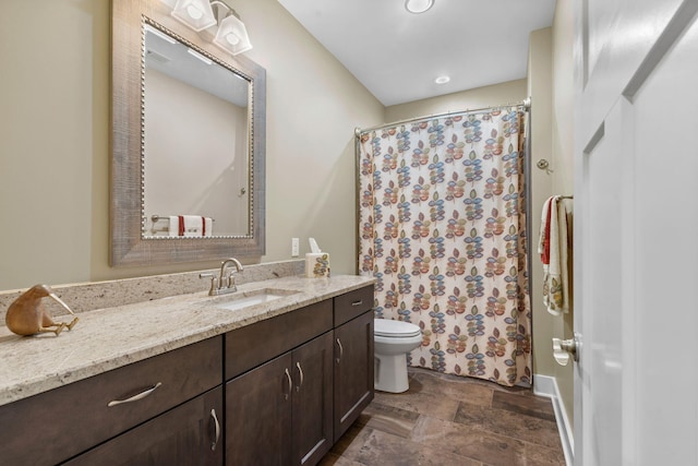 bathroom featuring toilet, vanity, and a shower with curtain